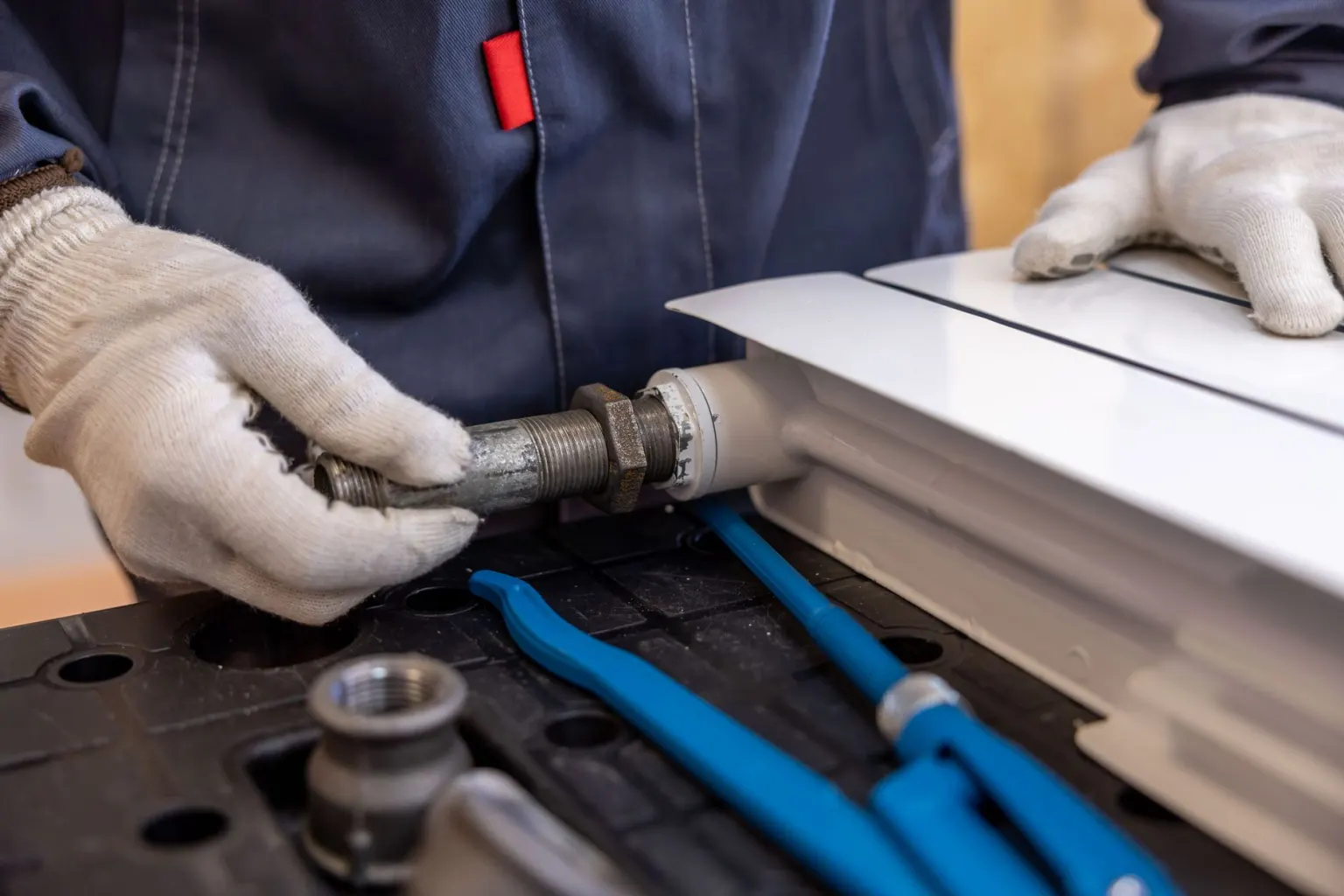 Heating engineer fitting pipework to a radiator